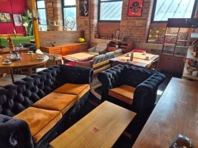 Black Chesterfield sofas and teak pieces among the windows on the Scandex floor