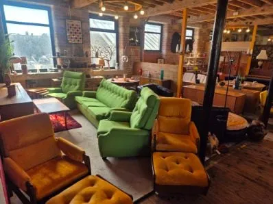 Green velvet sofas and mustard armchairs on the Scandex floor at Cullingworth Mills