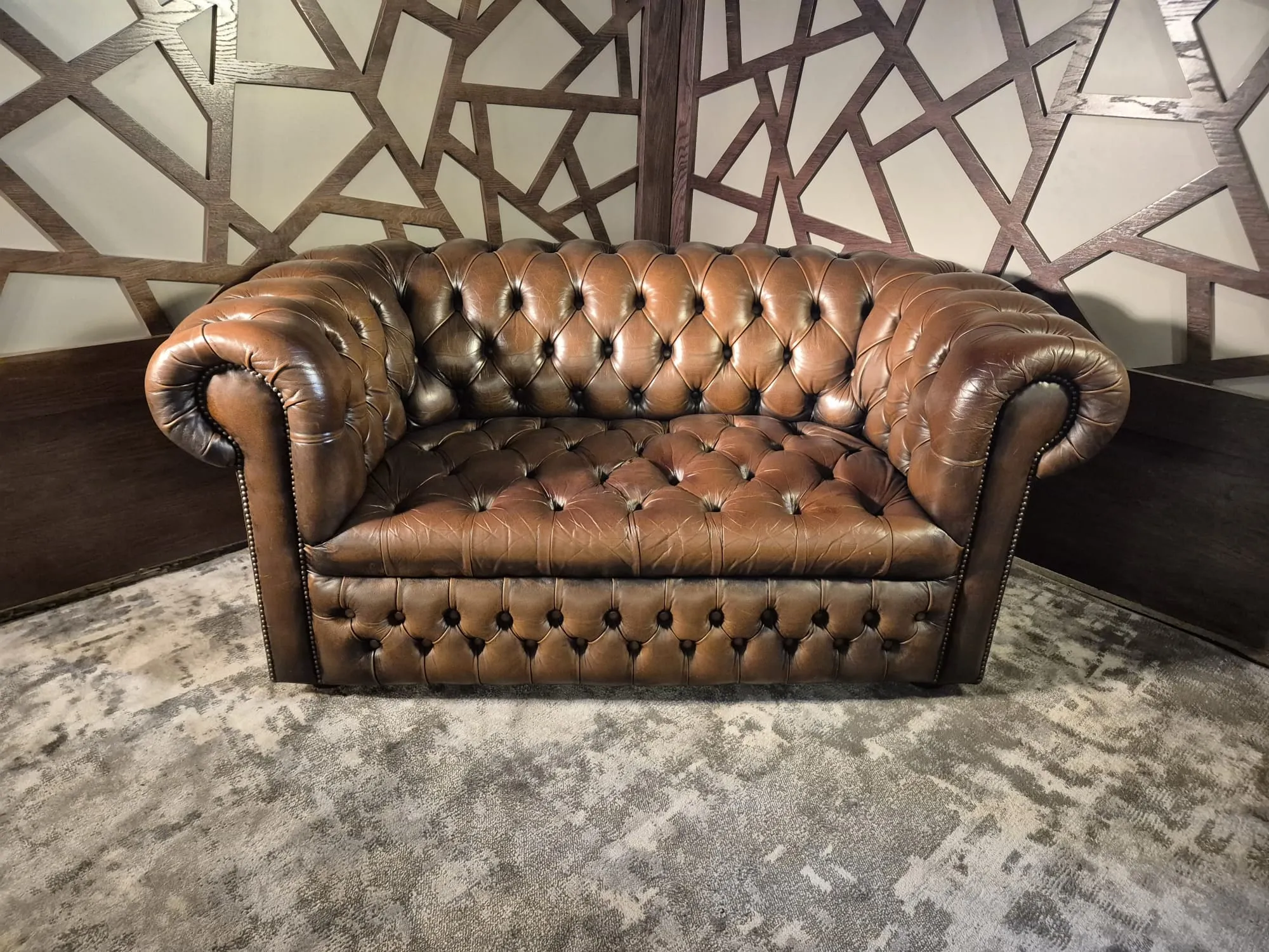 Tan buttoned-leather Chesterfield two-seater sofa at Scandex, Cullingworth.